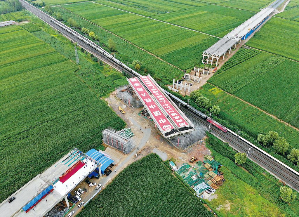 在周南高速公路上跨京广铁路转体桥转体施工现场一列火车从京广铁路上