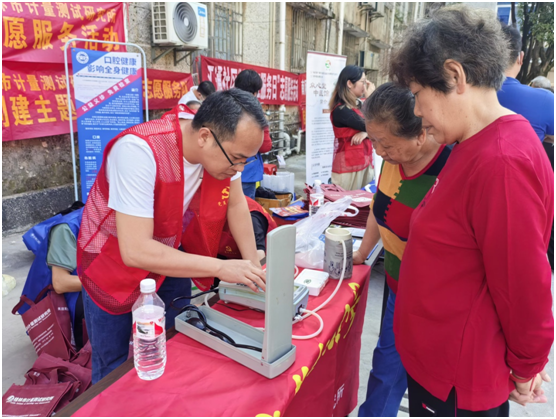 广西桂林市计量测试研究所：计量惠民进社区 志愿服务“零距离”_党员志愿者为居民检测血压计.png_c842dda7e7694c958fbb8811abaa6467.png