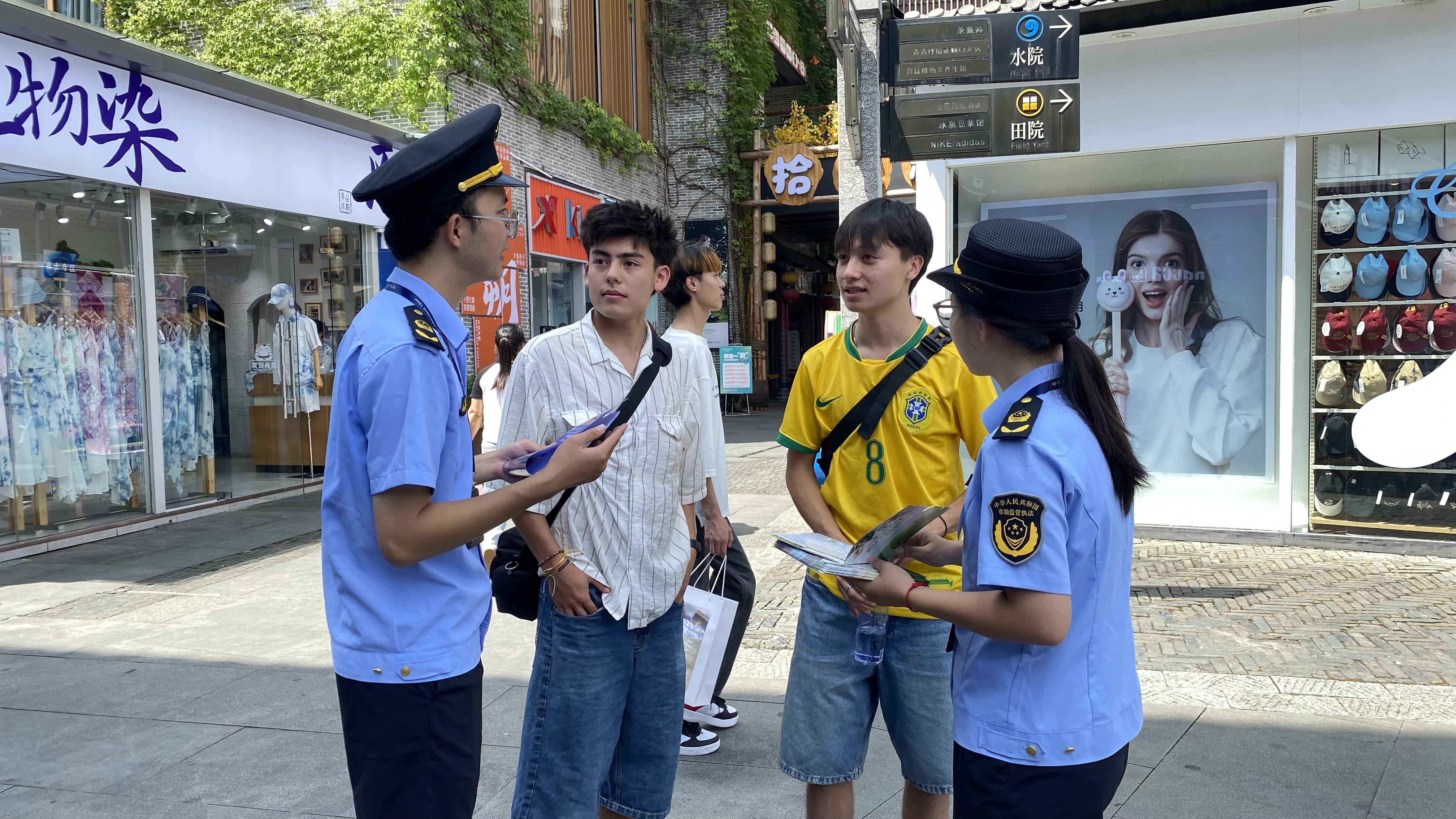 游客指尖“扫码点检”监管即刻检测！广西桂林“点单式监管”守护舌尖安全_工作人员向游客介绍食品安全点检活动_fab15541e6ba4a8ca40b69620110094f.jpg
